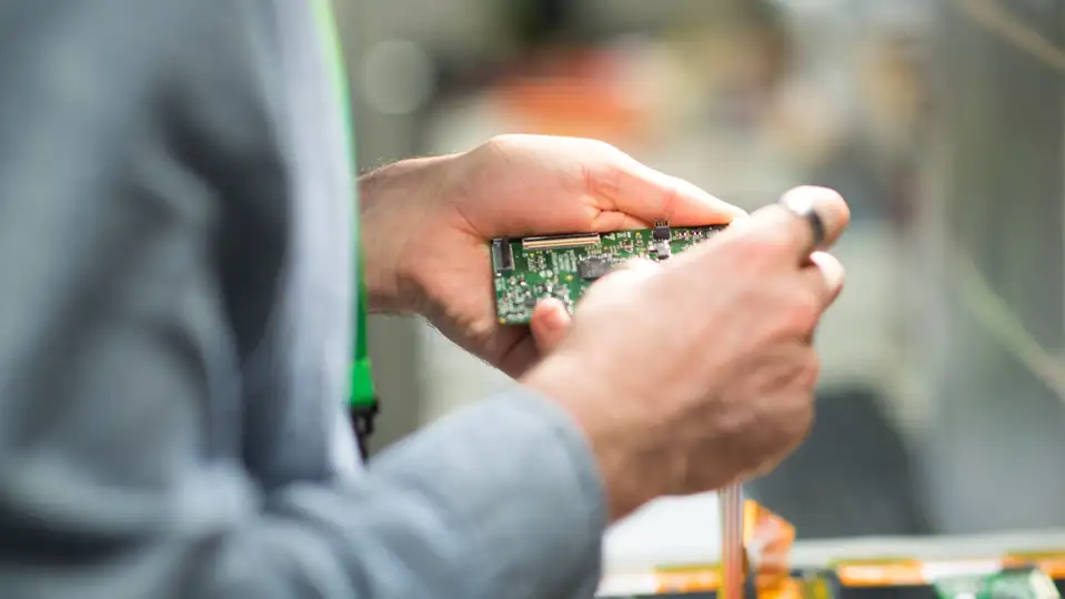 A man holding a PCB board